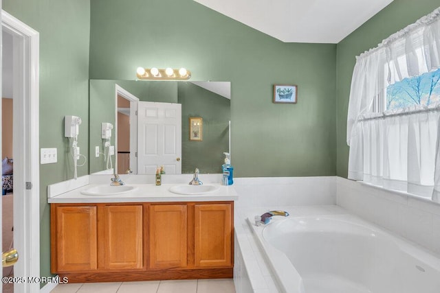 full bath featuring tile patterned flooring, double vanity, a sink, and a bath