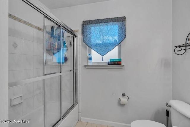 full bathroom featuring baseboards, combined bath / shower with glass door, and toilet