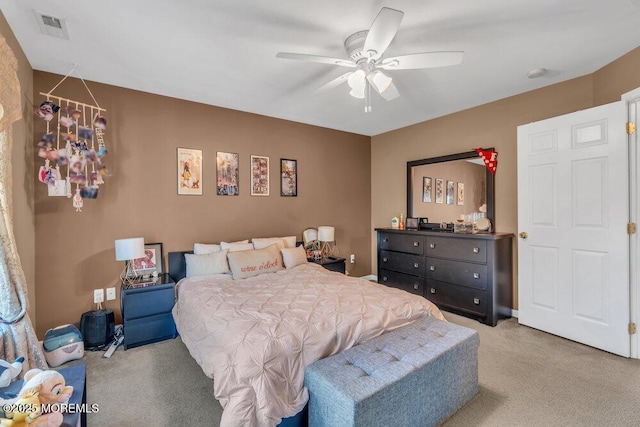 bedroom featuring a ceiling fan, visible vents, and light colored carpet