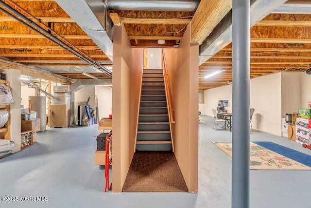 unfinished below grade area featuring gas water heater, stairway, and heating unit