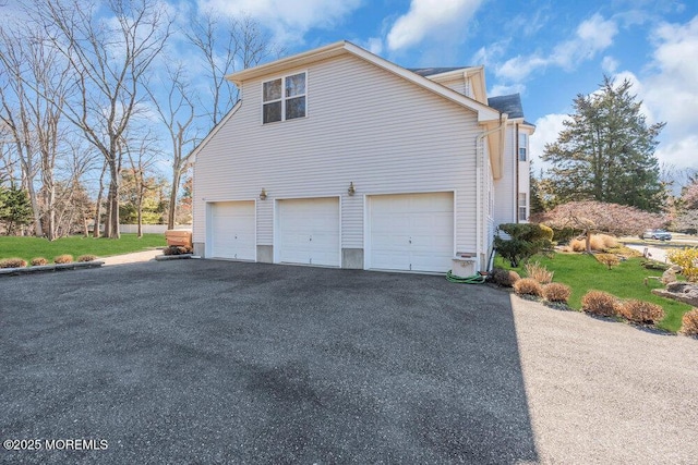 view of home's exterior with an attached garage and driveway