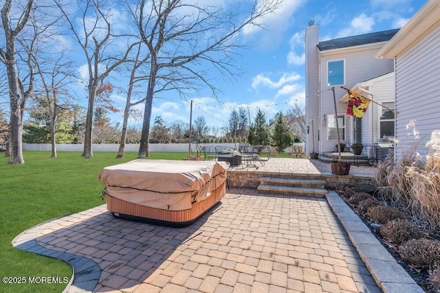 view of patio / terrace featuring fence and a hot tub