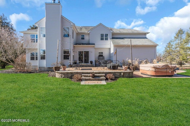 back of house with a patio, a yard, a chimney, and a hot tub