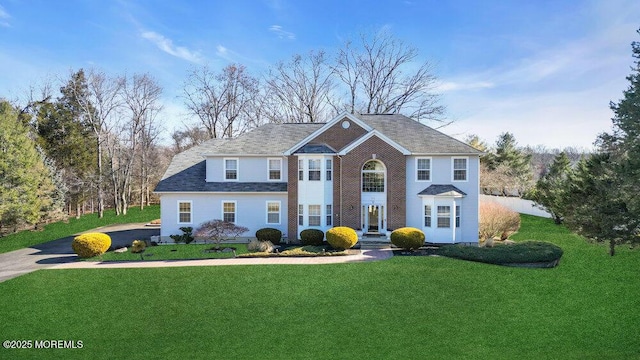 view of front of home with a front lawn and brick siding