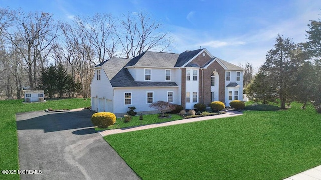 view of front of property featuring driveway, an attached garage, and a front yard