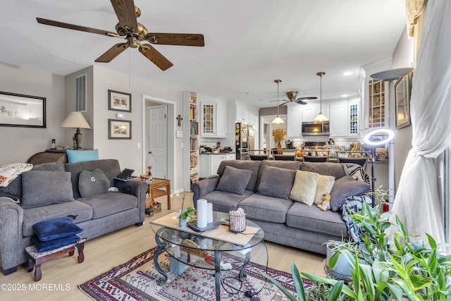 living room with ceiling fan and light hardwood / wood-style floors