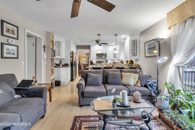 living room with ceiling fan and light hardwood / wood-style floors