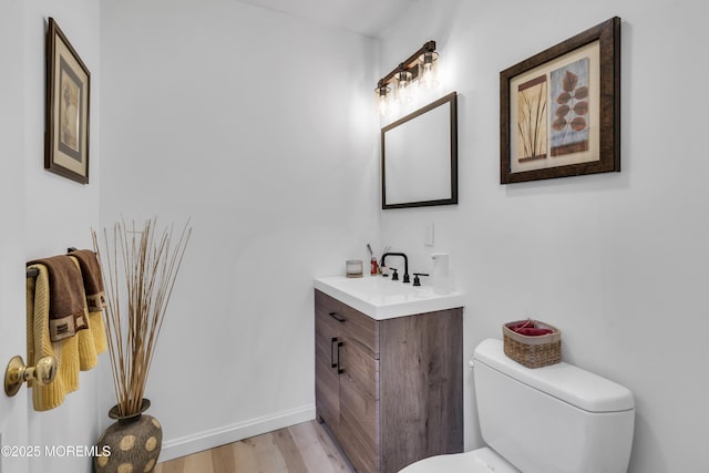 bathroom with vanity, toilet, and hardwood / wood-style floors