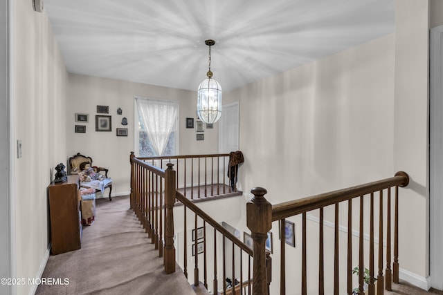 corridor featuring a chandelier and carpet floors