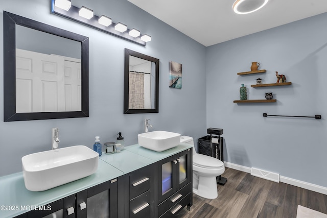 bathroom with hardwood / wood-style flooring, vanity, and toilet