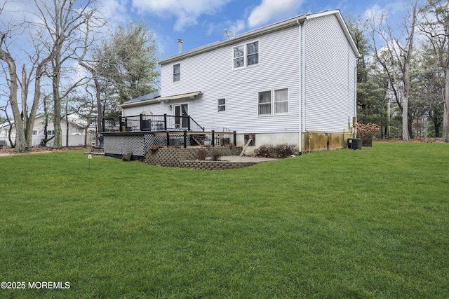 rear view of house featuring a deck and a lawn