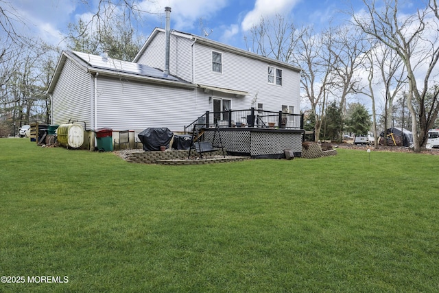 back of house with a deck and a lawn