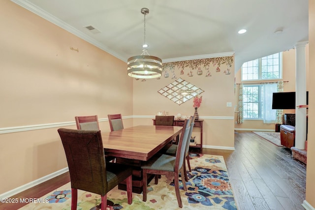 dining space with crown molding, wood finished floors, visible vents, and baseboards