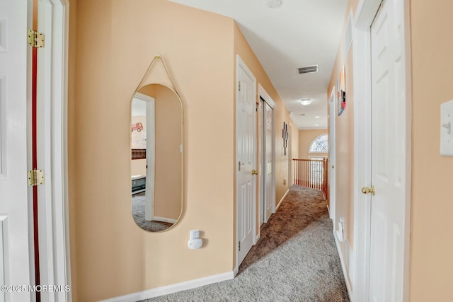 corridor featuring carpet flooring, baseboards, and visible vents