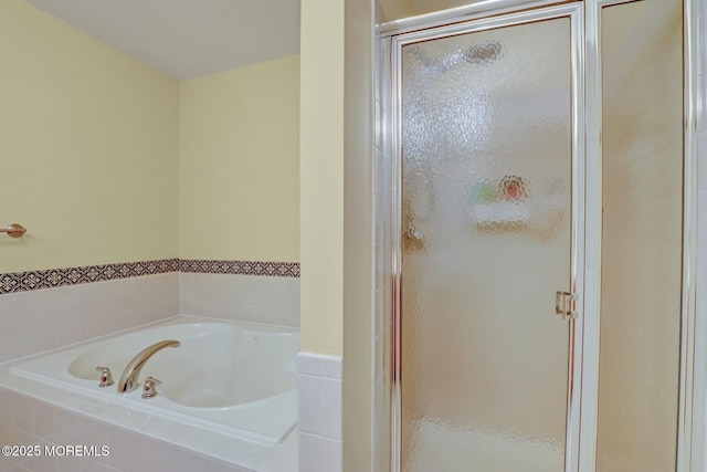 full bathroom featuring a garden tub and a shower stall