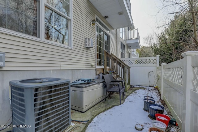 view of property exterior with central AC unit and fence