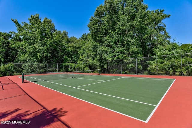 view of tennis court featuring fence