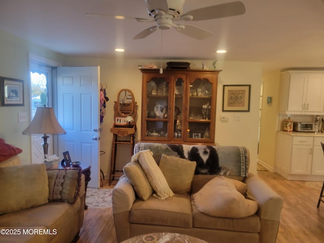 living room with light hardwood / wood-style floors and ceiling fan