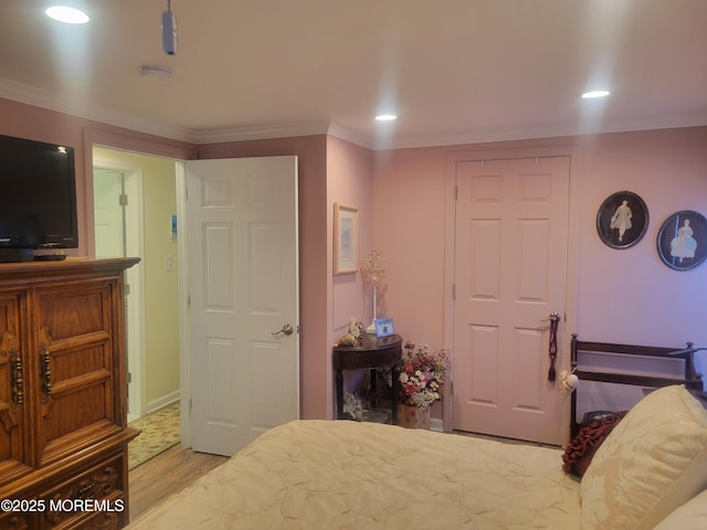 bedroom featuring crown molding and light hardwood / wood-style floors