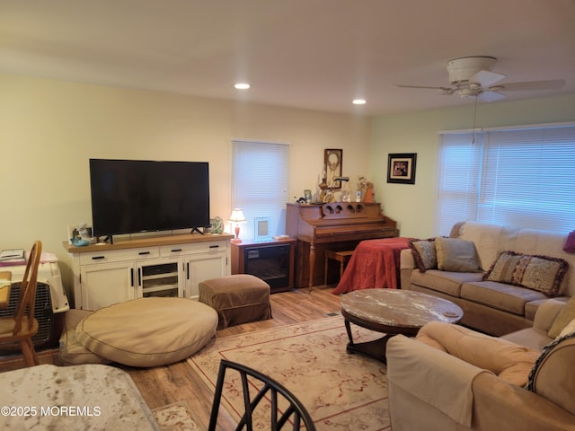 living room featuring ceiling fan, a wealth of natural light, and light wood-type flooring