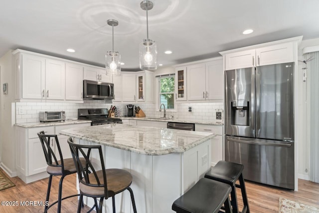 14 Douglas Dr, Jackson, NJ 08527 - kitchen with stainless steel appliances, a breakfast bar, white cabinets, glass insert cabinets, and light wood-type flooring