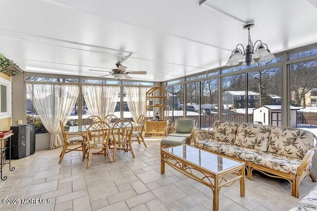 sunroom / solarium featuring ceiling fan with notable chandelier