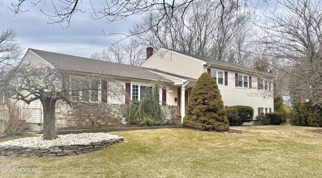 view of front of property with roof with shingles, a chimney, and a front lawn