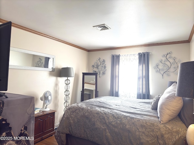 bedroom with ornamental molding and wood-type flooring