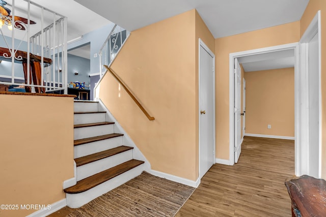 stairway featuring hardwood / wood-style flooring and ceiling fan