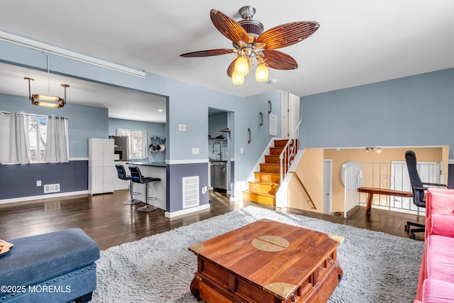 living room with ceiling fan, dark hardwood / wood-style floors, and sink