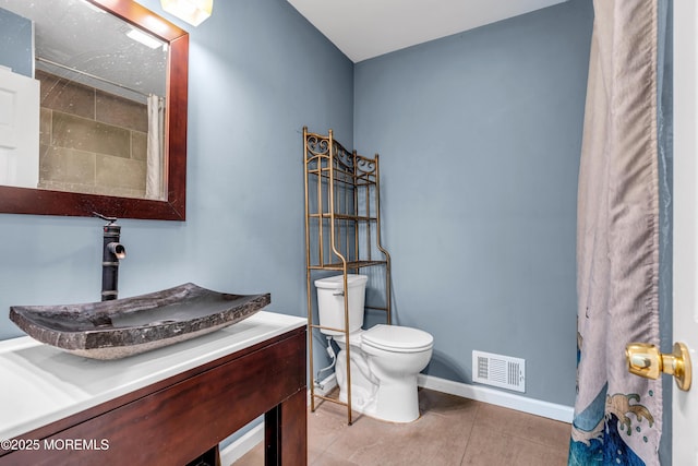 bathroom featuring vanity, tile patterned floors, and toilet