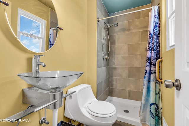 bathroom featuring toilet, curtained shower, and sink