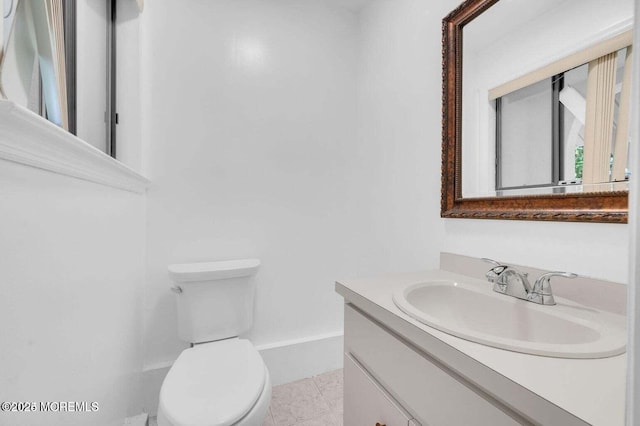 half bath featuring baseboards, vanity, toilet, and tile patterned floors