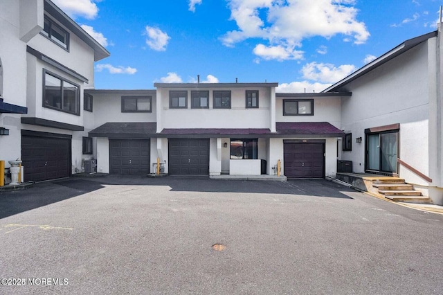 view of front of house with a garage and central air condition unit