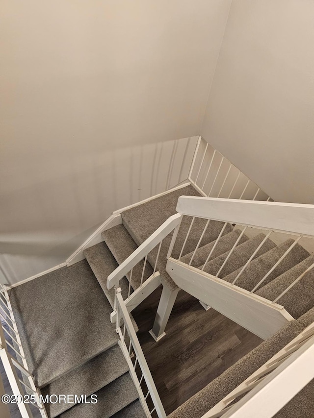 stairs with vaulted ceiling and wood finished floors