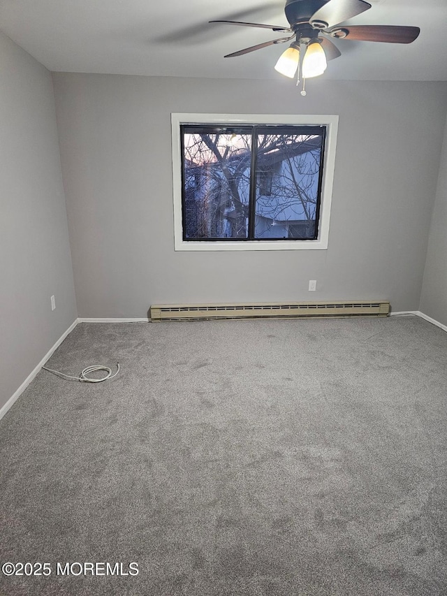 empty room with carpet floors, baseboard heating, a ceiling fan, and baseboards