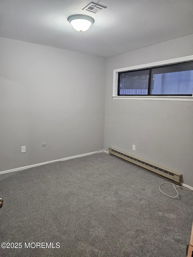 carpeted spare room with baseboards, visible vents, and baseboard heating