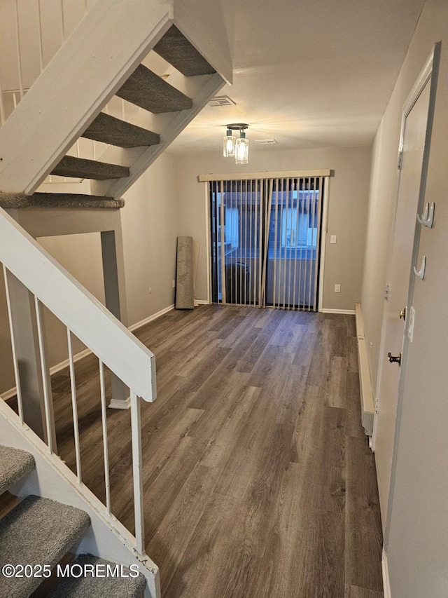 entryway featuring visible vents, stairs, baseboards, and wood finished floors