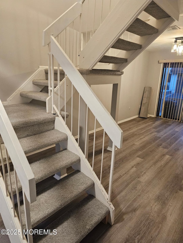 stairs featuring wood finished floors and baseboards