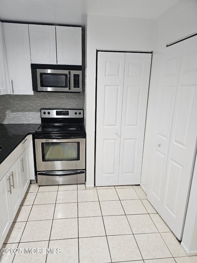 kitchen with white cabinets, stainless steel appliances, and light tile patterned flooring