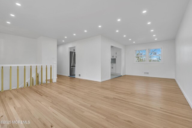 unfurnished room with light wood finished floors, baseboards, and recessed lighting