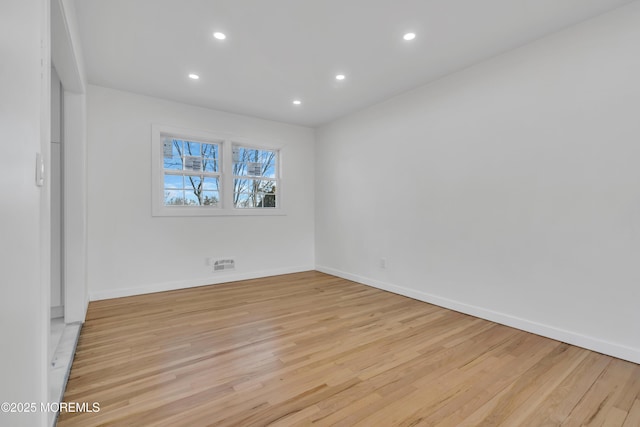 empty room with light wood-type flooring, baseboards, and recessed lighting