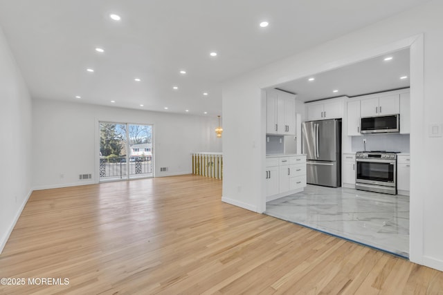 kitchen with recessed lighting, visible vents, appliances with stainless steel finishes, open floor plan, and white cabinetry