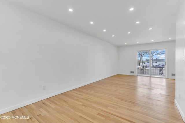 spare room with recessed lighting, visible vents, light wood-style flooring, and baseboards