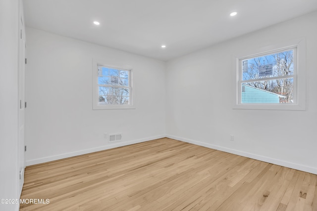 unfurnished room with baseboards, visible vents, wood finished floors, and recessed lighting