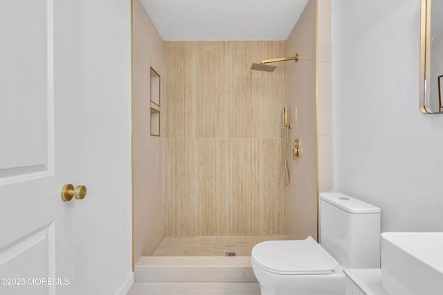 full bathroom featuring tiled shower, vanity, and toilet