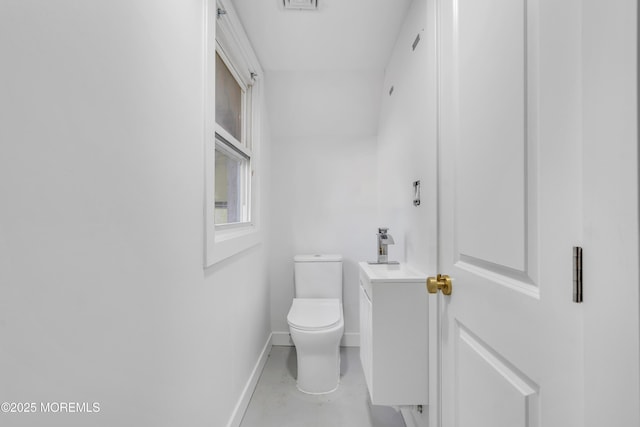 half bathroom with toilet, baseboards, and vanity