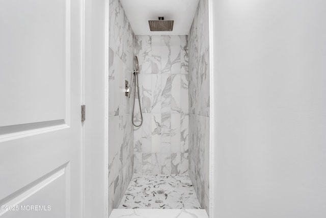 bathroom featuring a marble finish shower