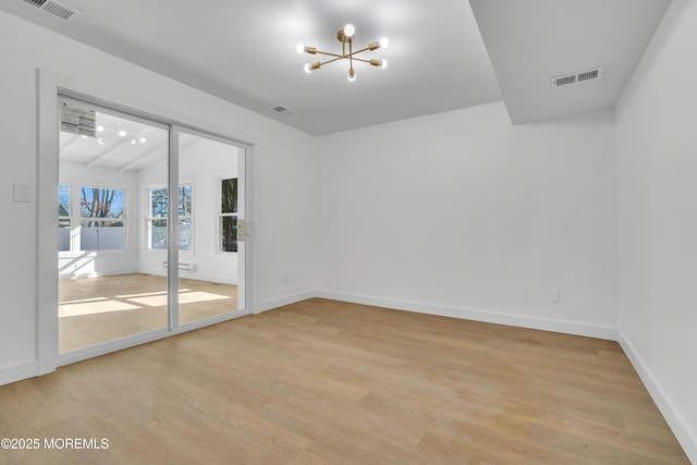 unfurnished room featuring light wood-style flooring, visible vents, and baseboards