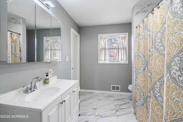 bathroom with a healthy amount of sunlight, toilet, and vanity